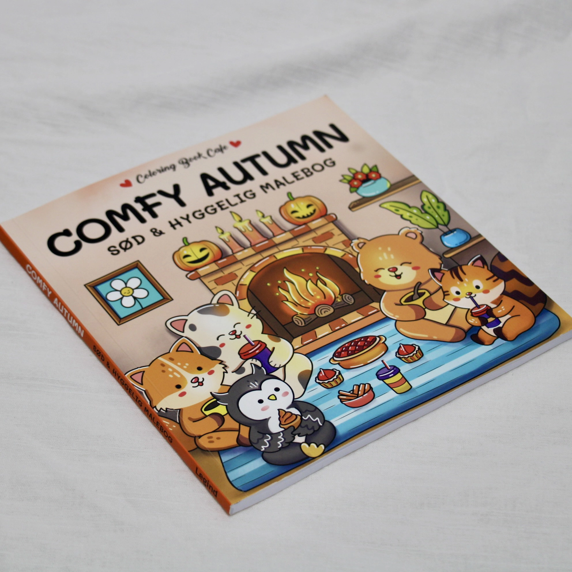Forside af Comfy Autumn malebog med efterårsmotiver, blade og hyggelige farver.